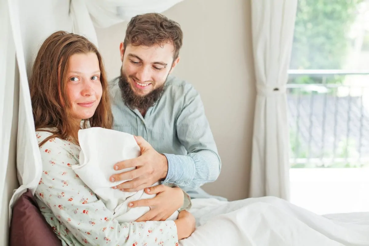 Frau mit Partner im Kreißsaal Frühwochenbett zu Hause beginnen