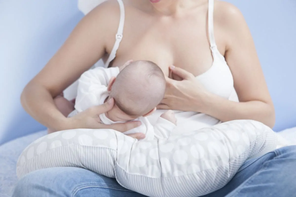 Mutter stillt auf Stillkissen Mutter stillt Baby mit Stillkissen
