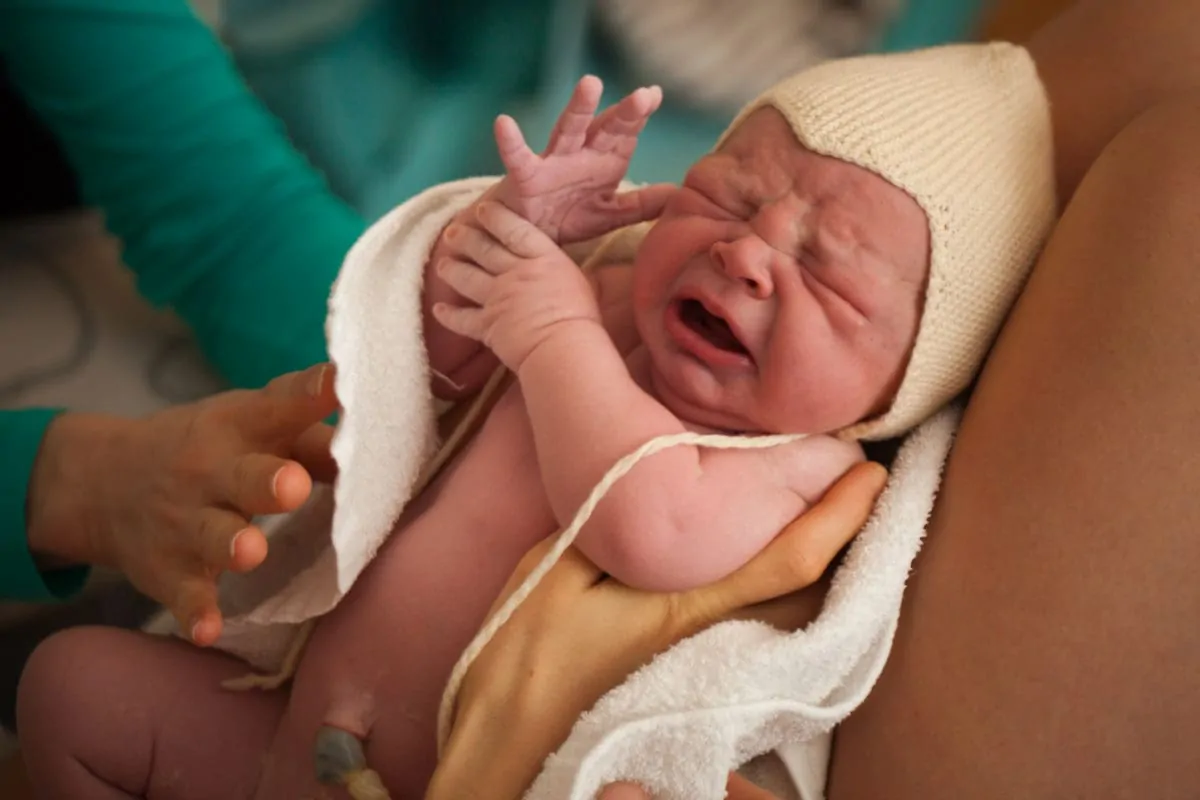 Neugeborenes mit Nabelschnur ambulante Geburt Baby