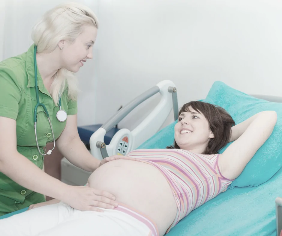 aeussere wendung bei beckenendlage Ärztin tastet manuell die Lage des Babies